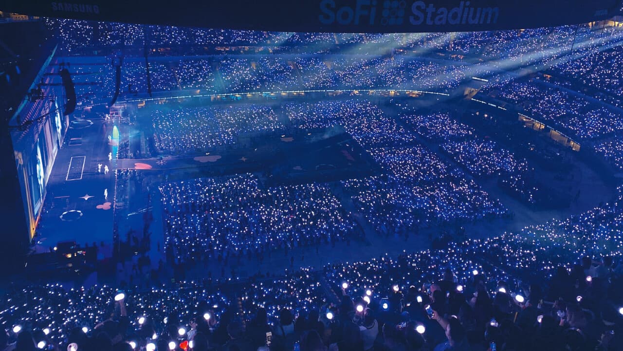 BTS performing before a sea of ARMY lights at SoFi Stadium during their world tour