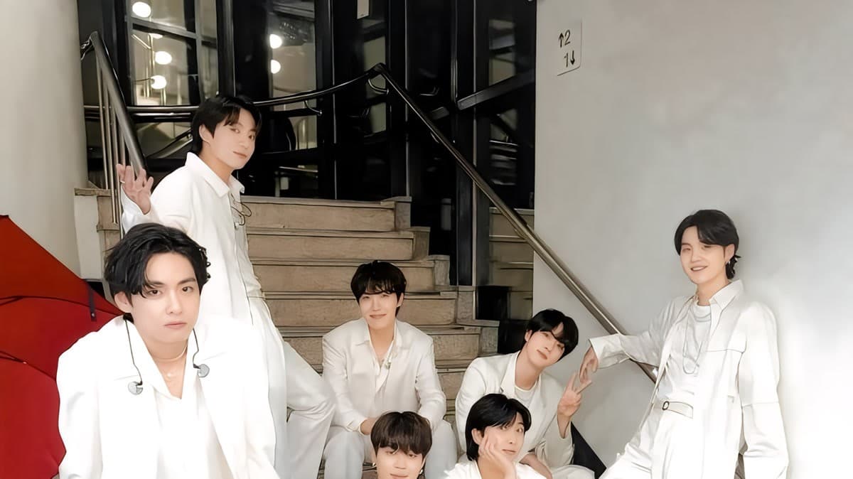 BTS members posing together in matching white outfits