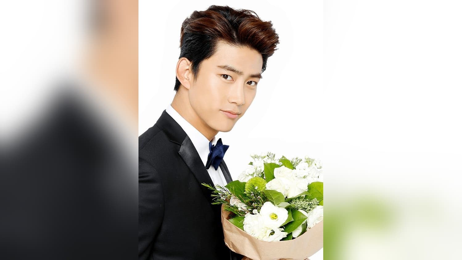 Ok Taecyeon in a formal suit holding white flowers, celebrating his wedding day on April 24, 2026