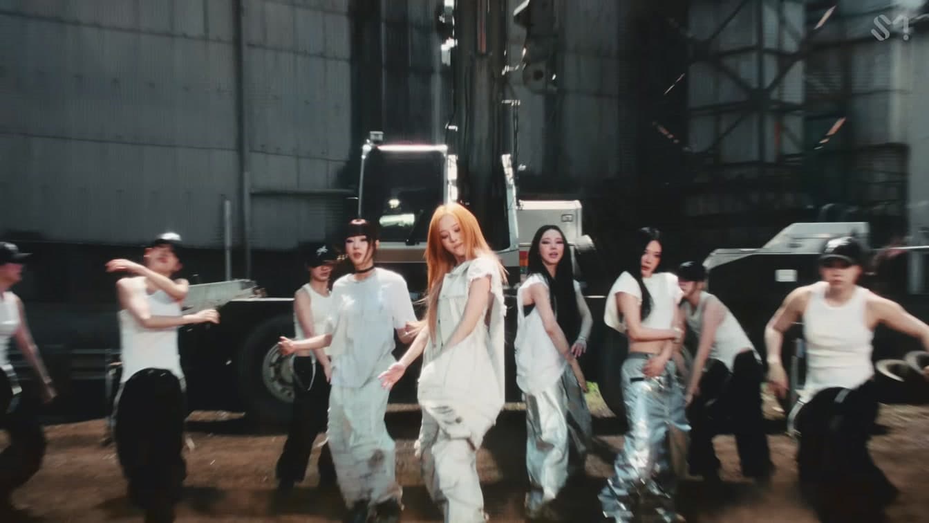 aespa performs in an official LEMONADE-era video frame as Winter's campus festival buzz builds comeback momentum.