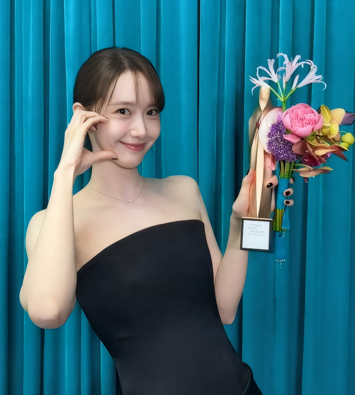 Lim Yoona poses with her Popularity Award at the 62nd Baeksang Arts Awards in her black tube-top dress, May 8, 2026